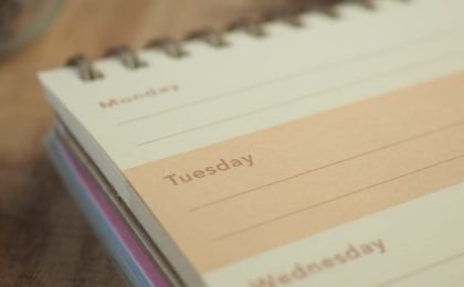 Entrepreneur looking at a weekly calendar with one empty day, representing guilt about taking a day off.